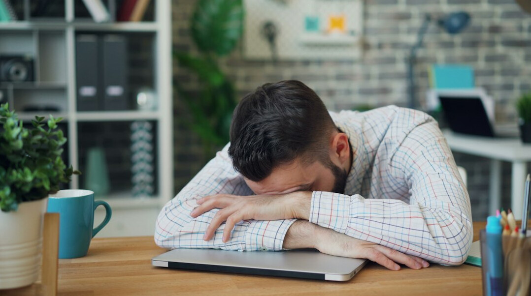 person feeling tired at desk